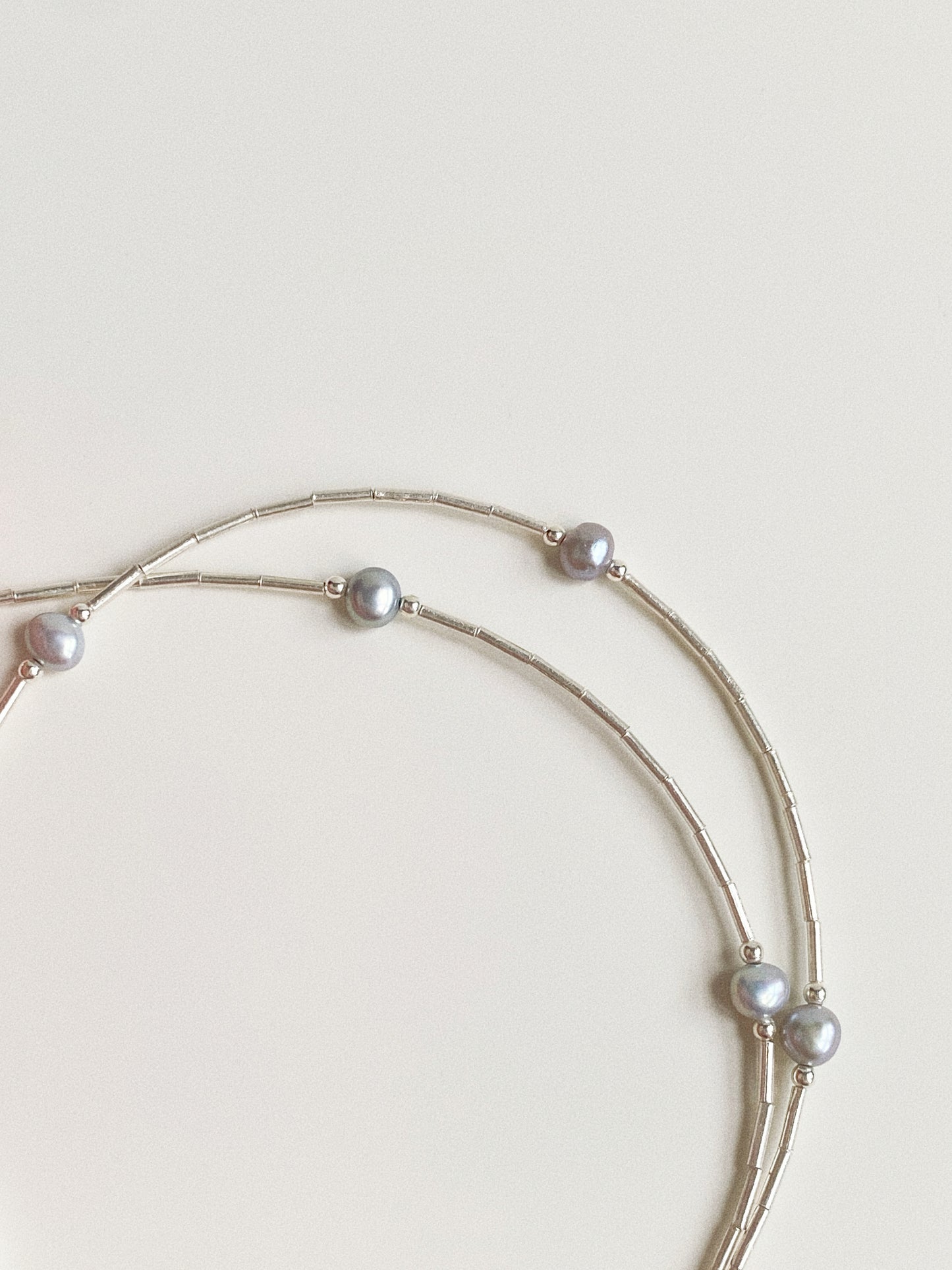 Detail of station-style pearl spacing on natural grey pearl and sterling silver necklace