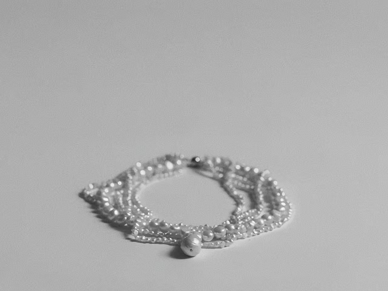 Artistic photography of a multi-strand freshwater pearl choker, showcasing the texture and volume of the necklace.