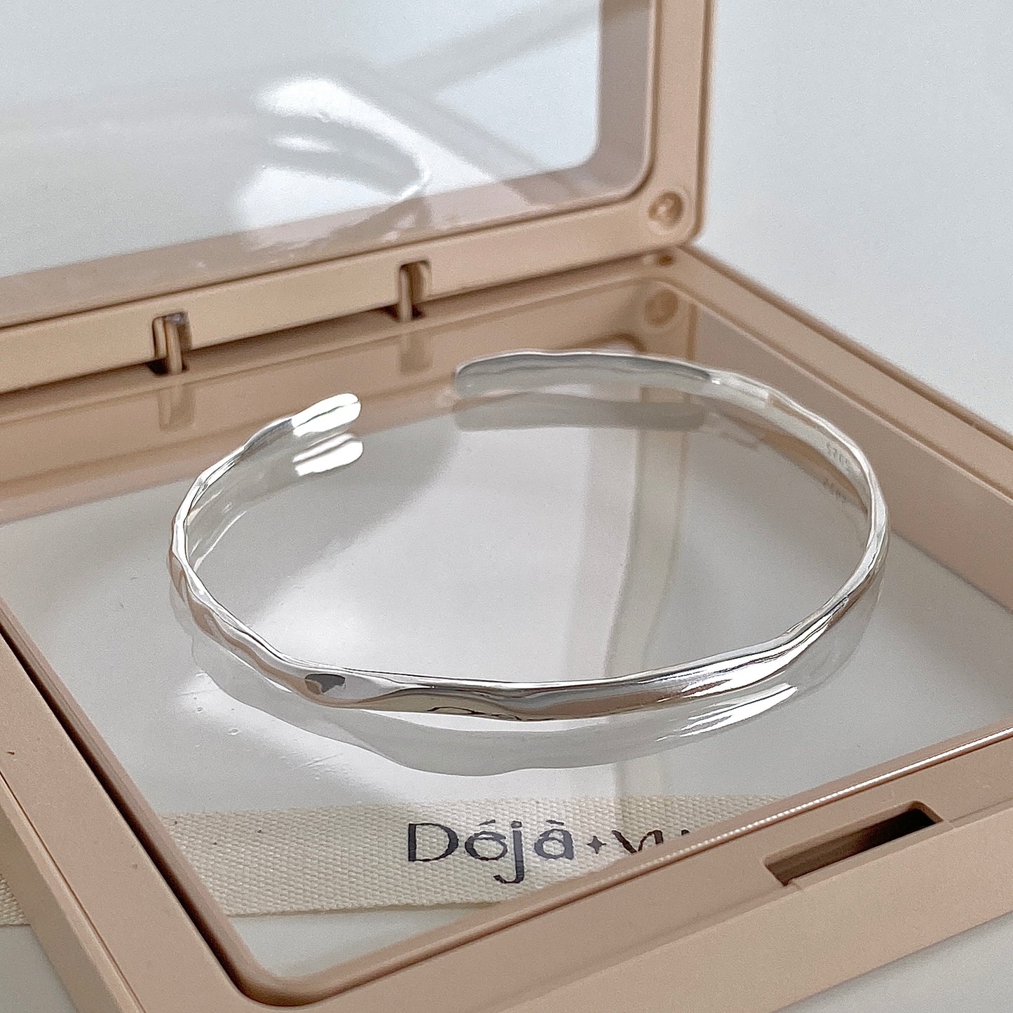 Faceted 925 silver cuff bangle in a jewellery case showing the soft hammered texture catching the light
