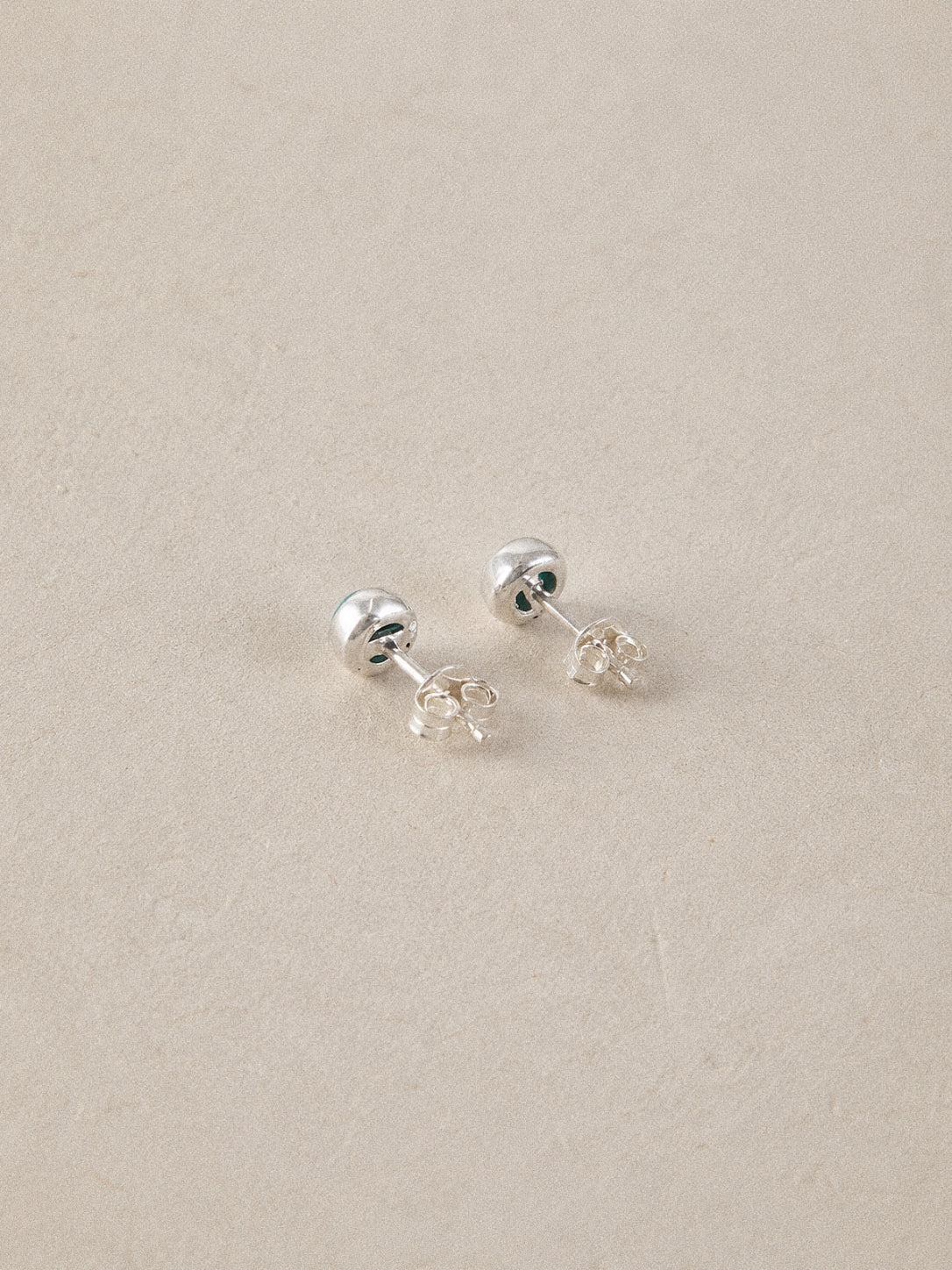 Back view of the turquoise stud earrings showing solid 925 sterling silver posts and butterfly backs.