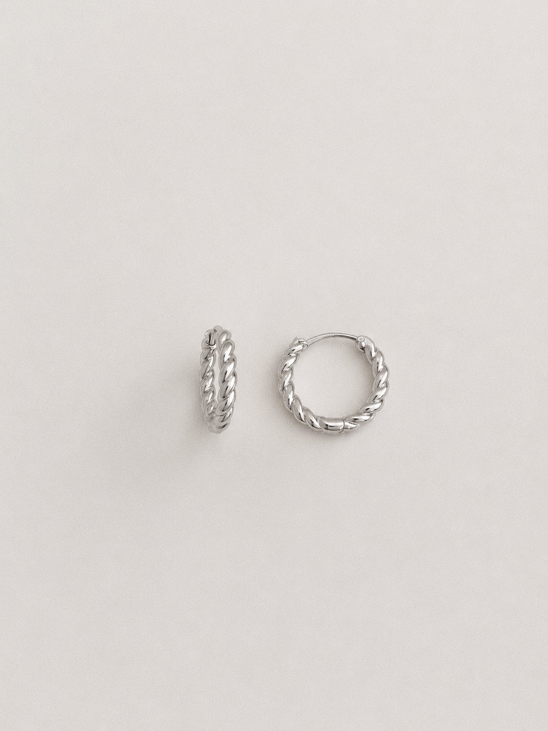 Silver twisted rope huggie hoop earrings in 925 sterling silver shown upright and flat, small 10mm everyday hoops