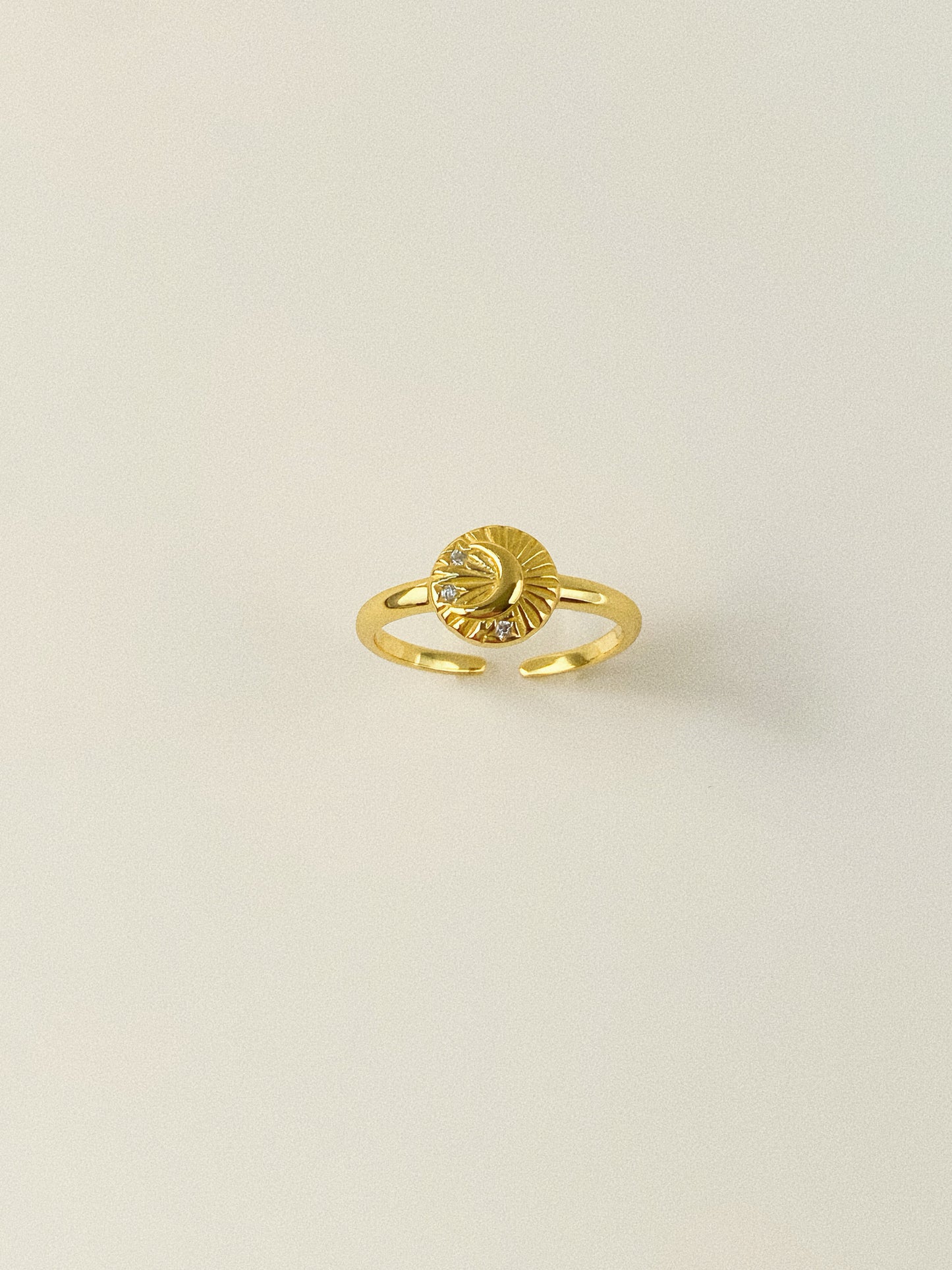 Detail shot of the 18k gold plated moon and star signet ring against a neutral background.