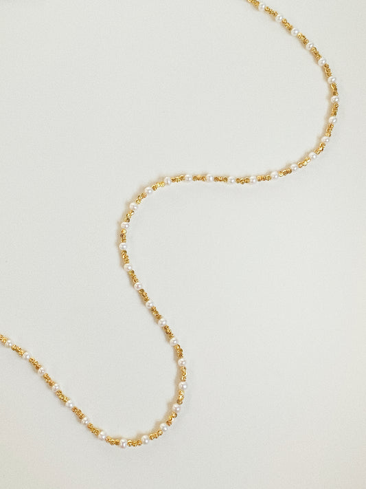 90cm long freshwater pearl and gold bead wrap necklace laid in S-curve flat lay
