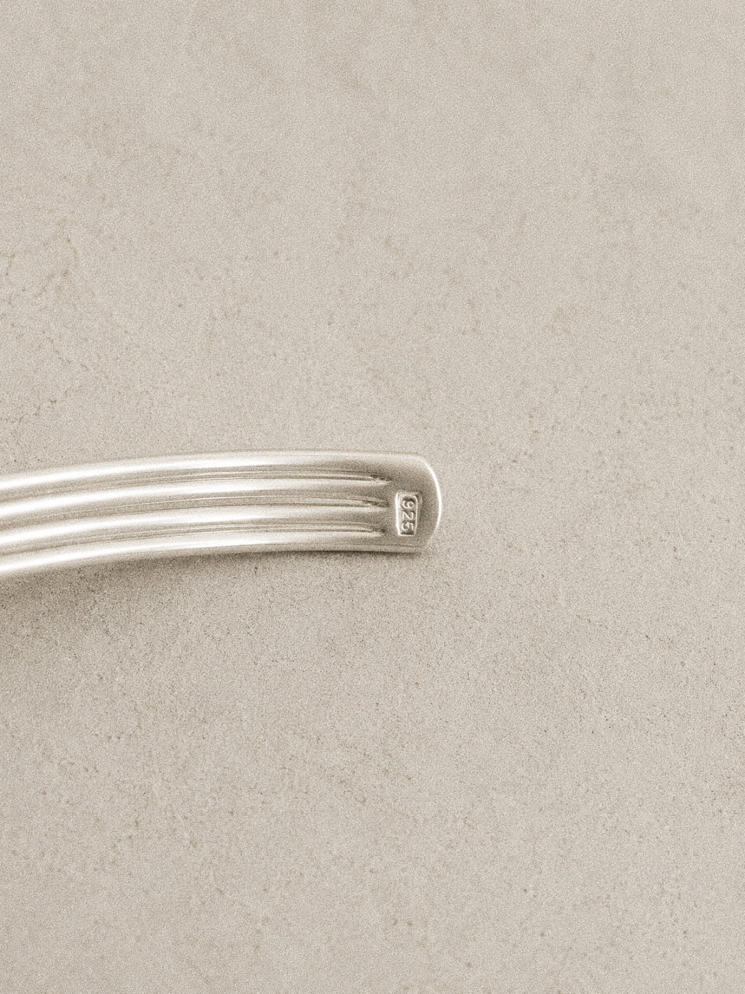 Close up of the 925 hallmark stamped on the ribbed end of the sterling silver knot bangle