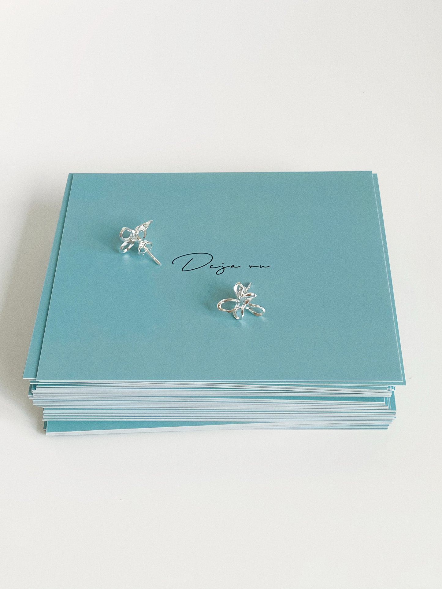 Sculptural silver flower studs with sterling silver posts shown on Deja Vu Jewellery branded packaging