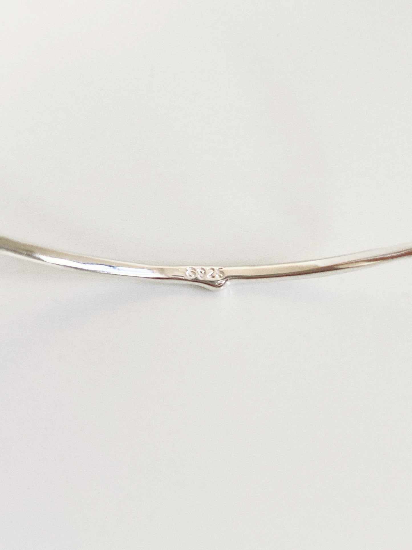 Close up of the S925 hallmark stamped on the sterling silver band of the Rivage cuff bangle