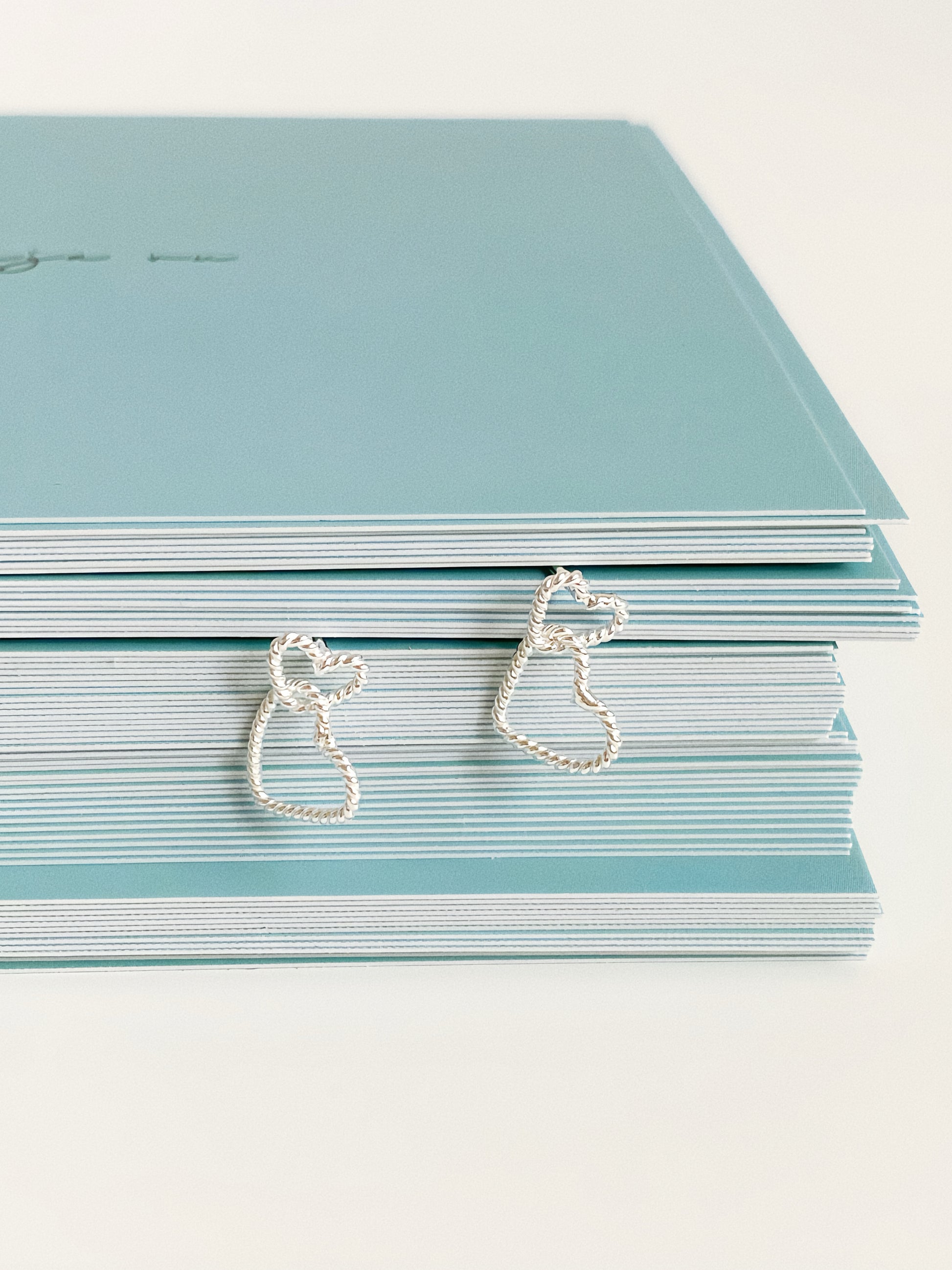 Close-up detail of double heart stud earrings showing twisted rope texture and linked heart design