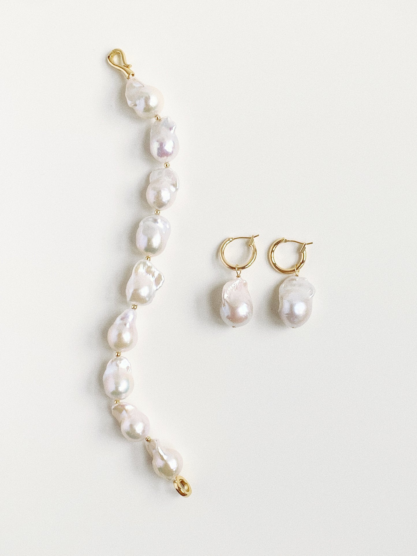 Styling inspiration showing the detachable pearl earrings paired with a matching baroque pearl bracelet.