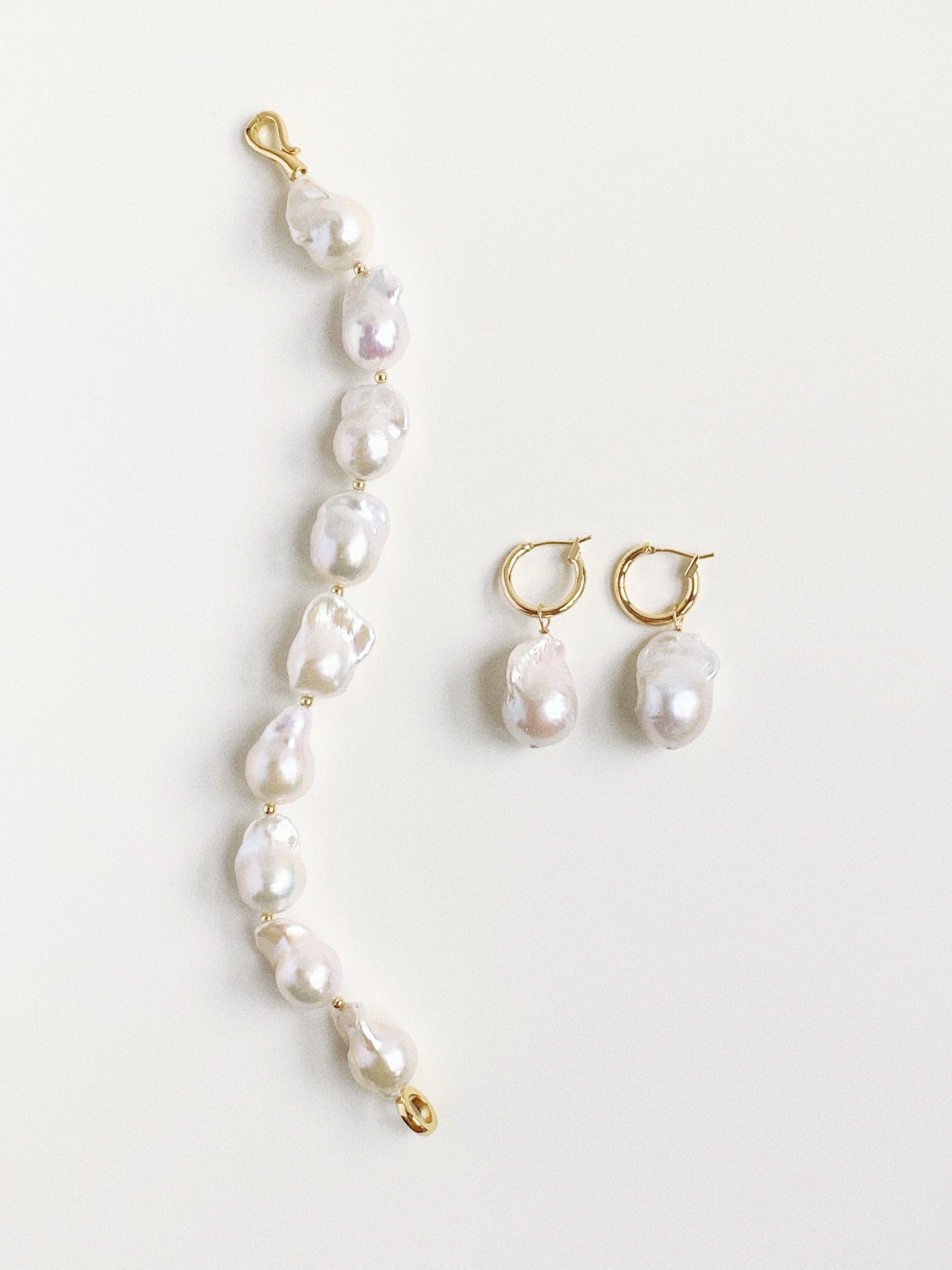 Styling inspiration showing the detachable pearl earrings paired with a matching baroque pearl bracelet.
