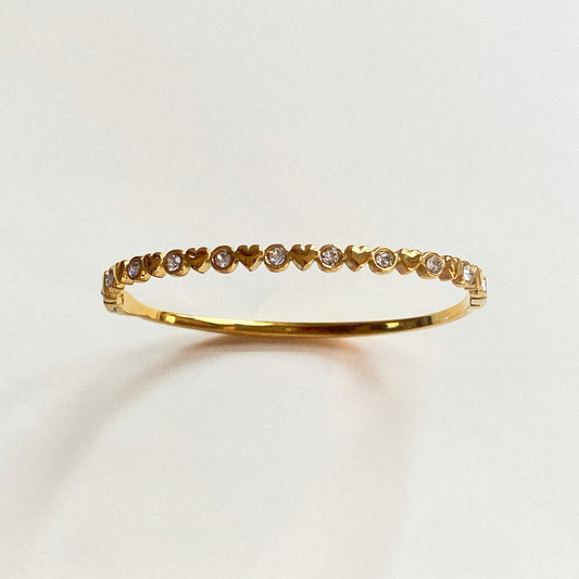 Minimal product shot of gold heart tennis bangle with bezel-set cubic zirconia – stainless steel, waterproof and hypoallergenic, 0.35 cm width