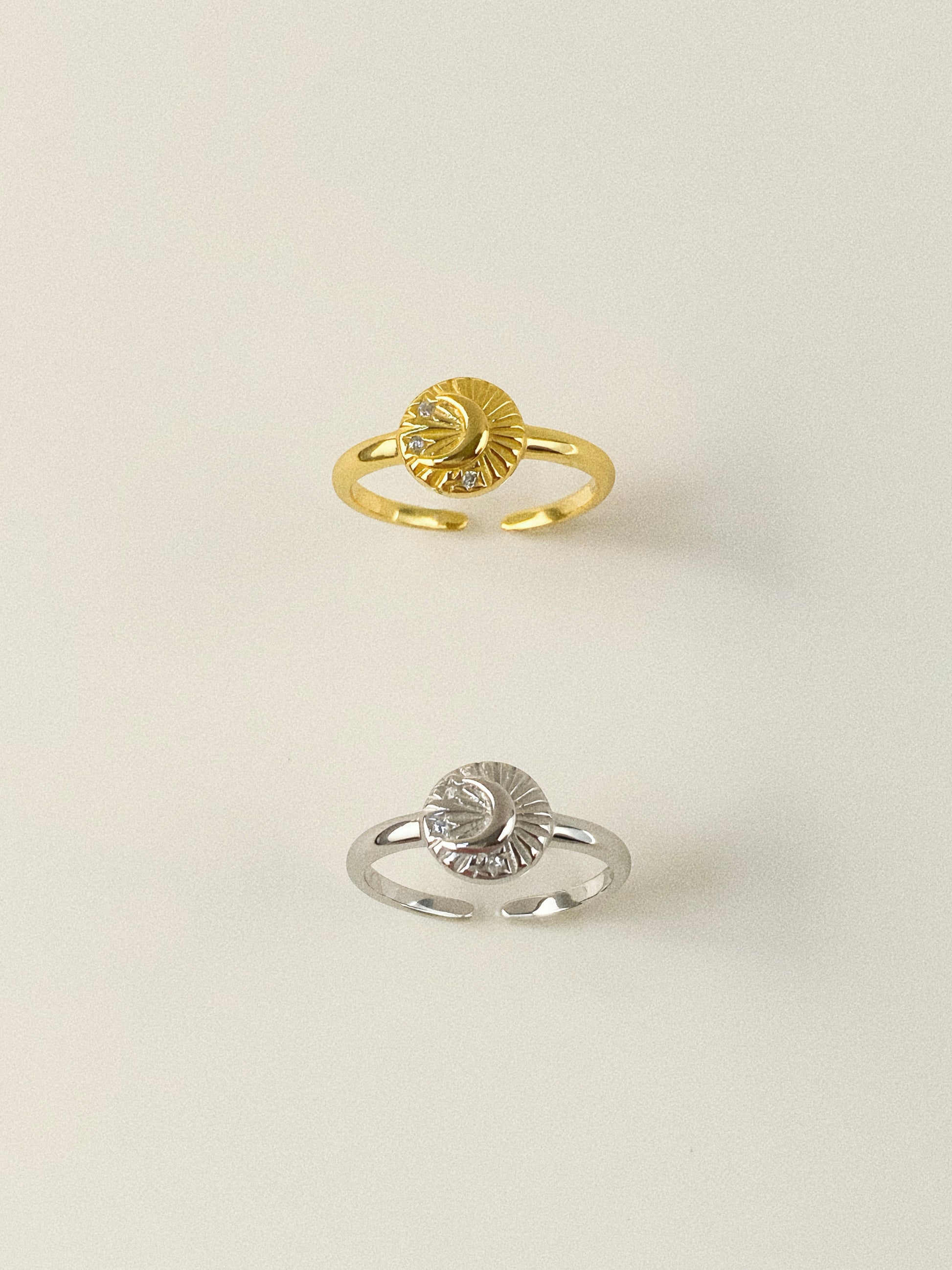 Top view of gold and silver celestial signet rings featuring crescent moon and star motifs.