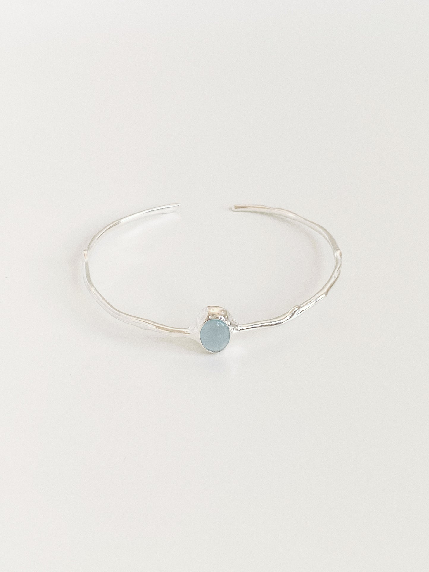 Front view of branch textured sterling silver open bangle set with pale blue aquamarine