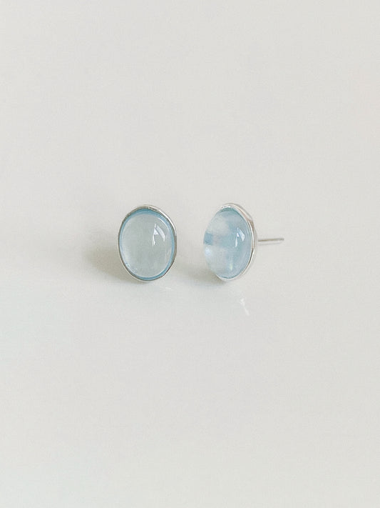 Aquamarine cabochon stud earrings shown from the front and side, revealing the domed stone and silver post