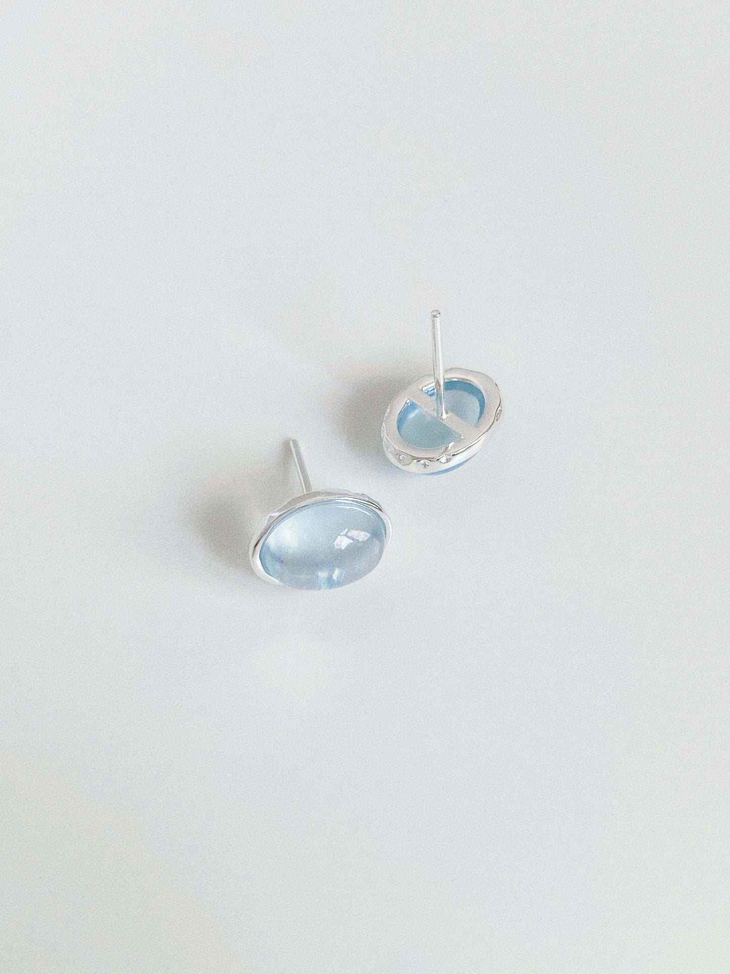 Front and back view of aquamarine cabochon studs showing the solid 925 sterling silver posts and bezel setting