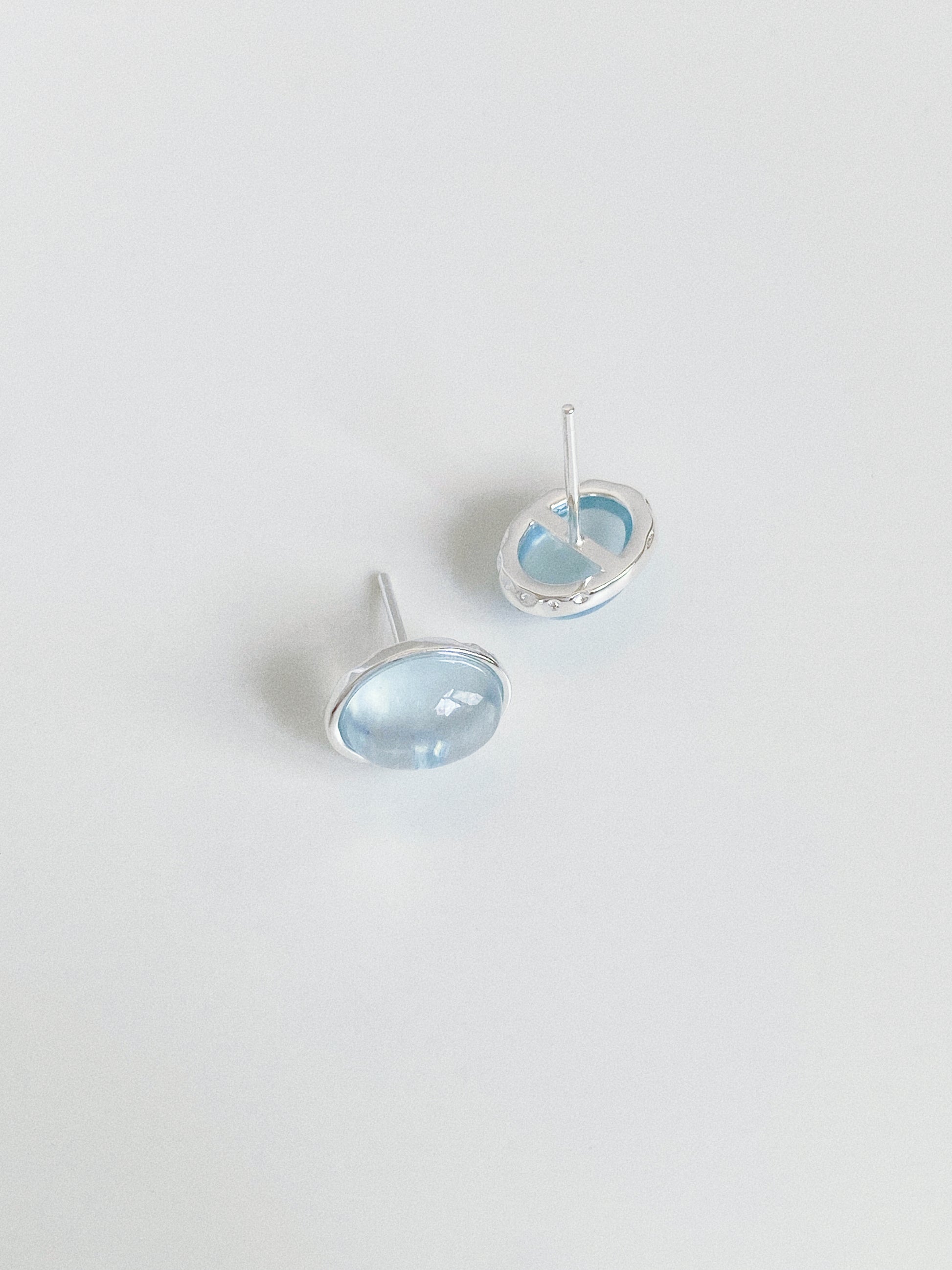Front and back view of aquamarine cabochon studs showing the solid 925 sterling silver posts and bezel setting