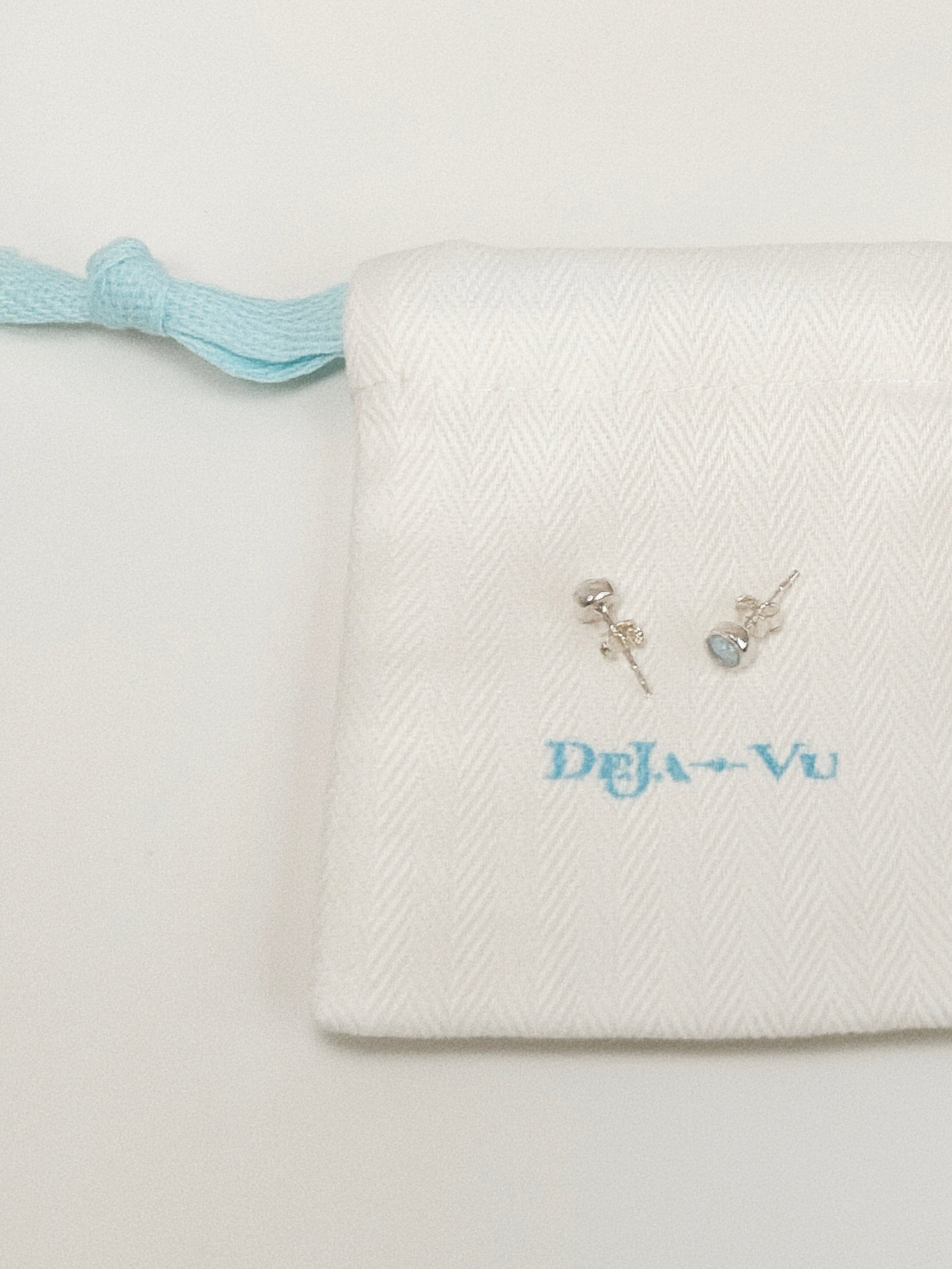 Natural blue topaz stud earrings styled with Deja Vu Jewellery branded embroidered pouch
