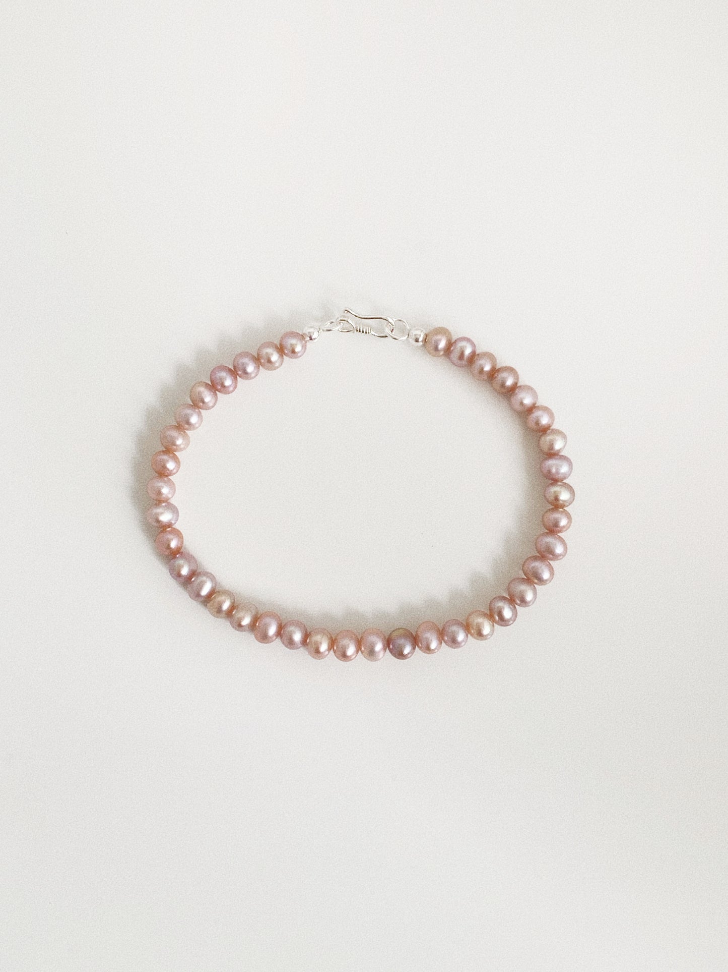 Dainty natural lavender pink freshwater pearl bracelet with a 925 sterling silver S-hook clasp on a warm white background