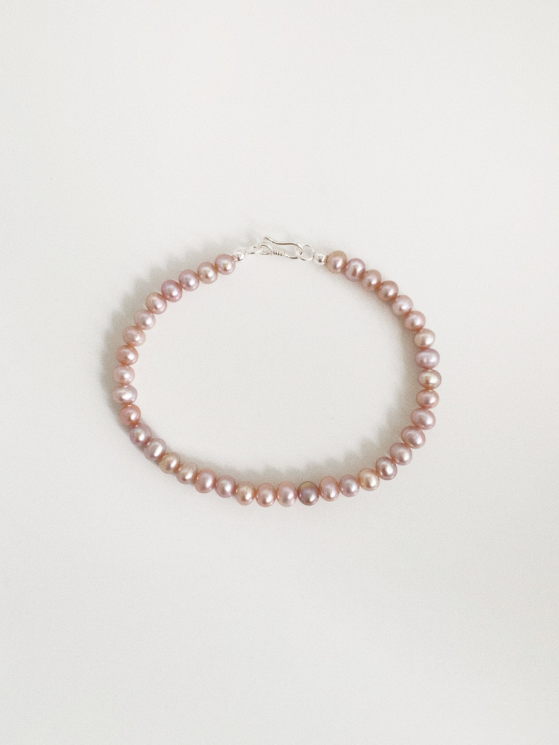  Dainty natural lavender pink freshwater pearl bracelet with a 925 sterling silver S-hook clasp on a warm white background