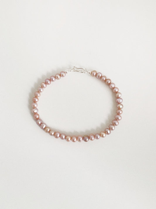  Dainty natural lavender pink freshwater pearl bracelet with a 925 sterling silver S-hook clasp on a warm white background