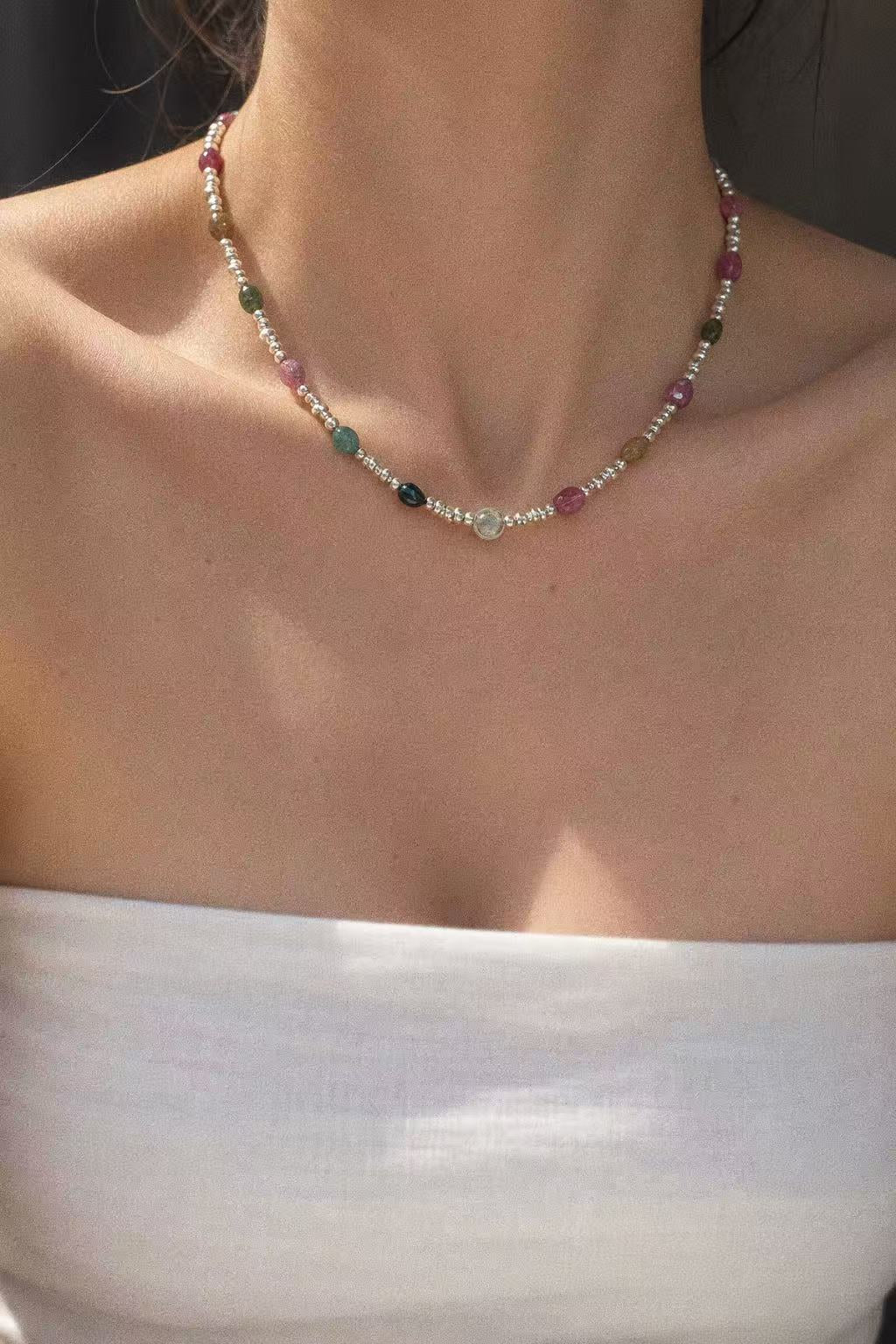 Bonbon tourmaline and sterling silver necklace worn at the neckline with a white top