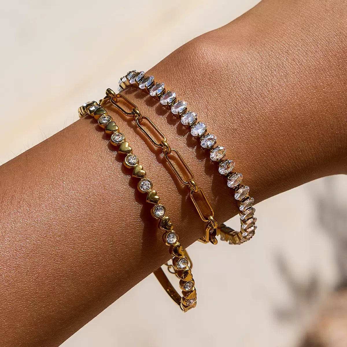 Adjustable gold paperclip chain bracelet styled in a summer wrist stack, waterproof hypoallergenic