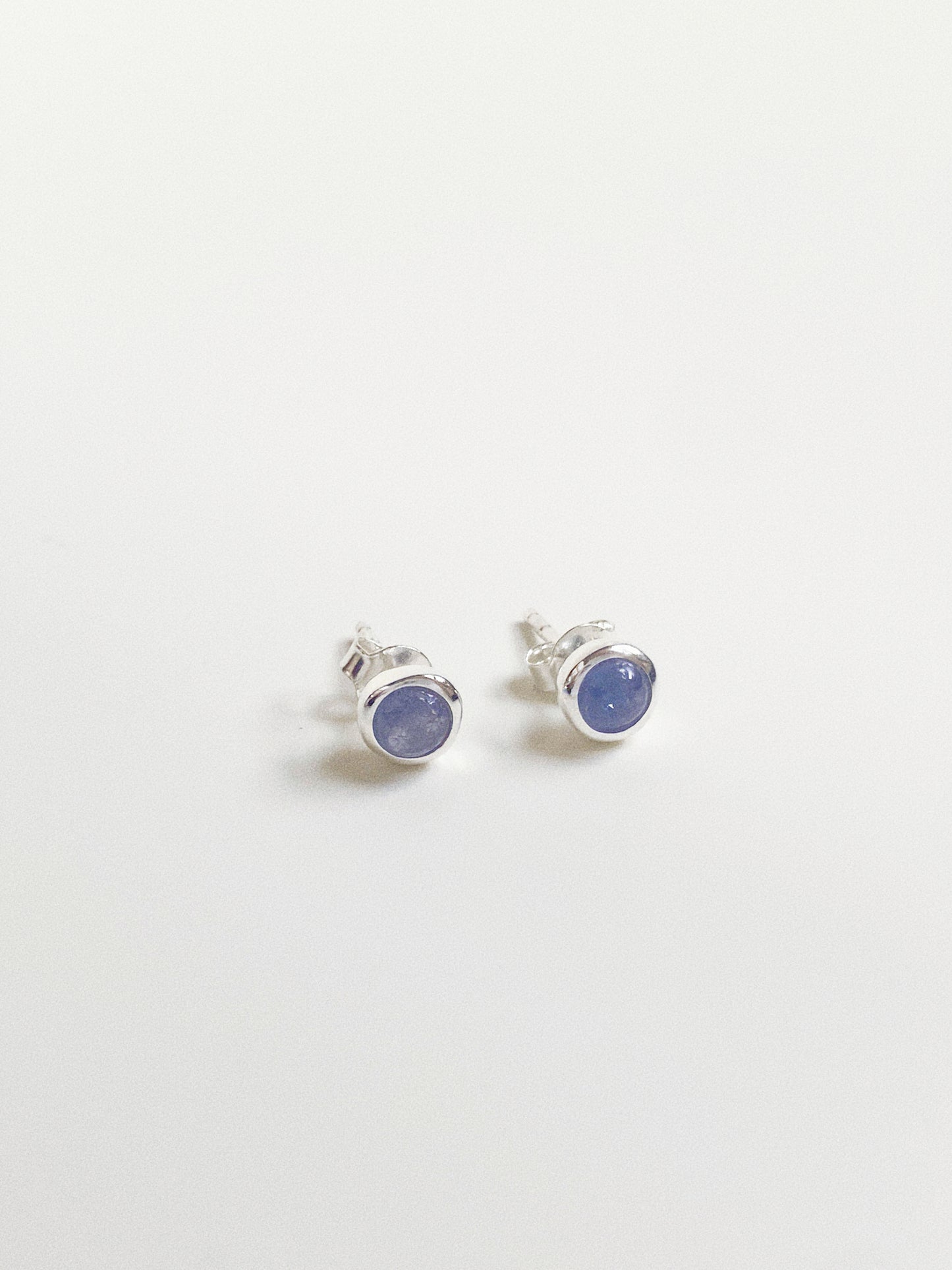 Angled view of blue gemstone studs showing the smooth dome shape and bubble silver setting.