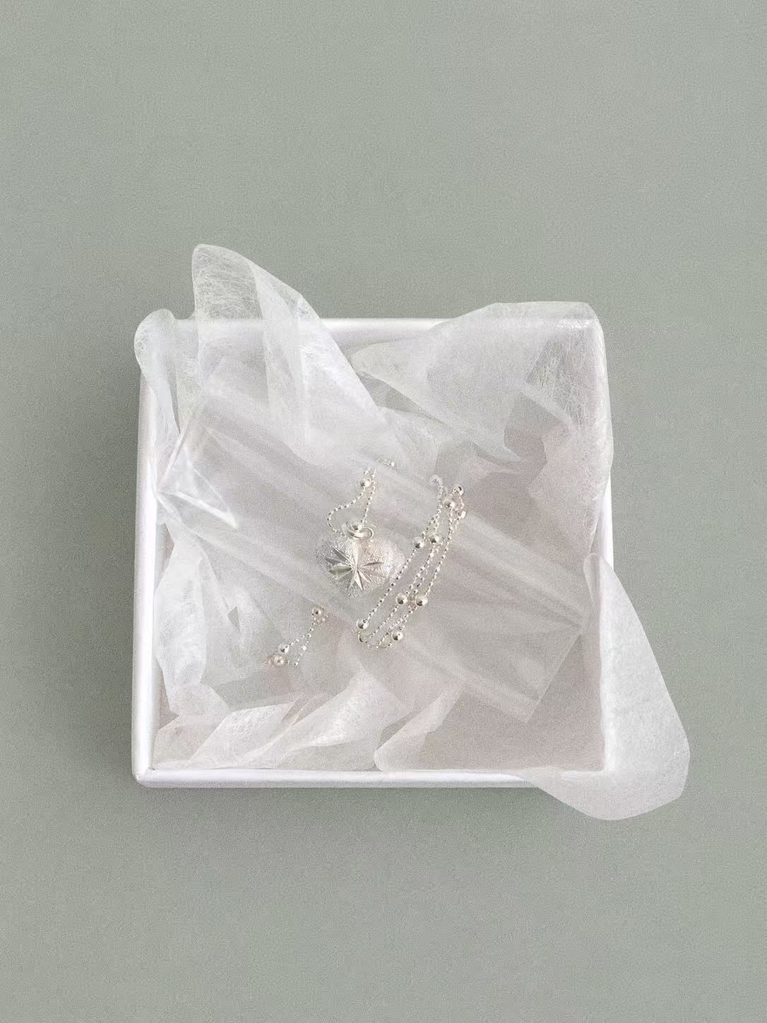 Complete Bubble Heart pendant and silver bead chain arranged in a white jewellery box.