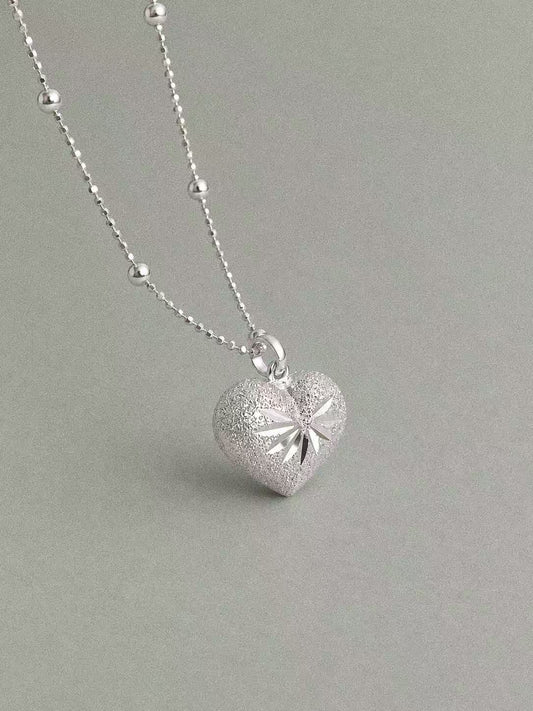 Bubble Heart sterling silver pendant with engraved starburst detailing on a silver bead chain.