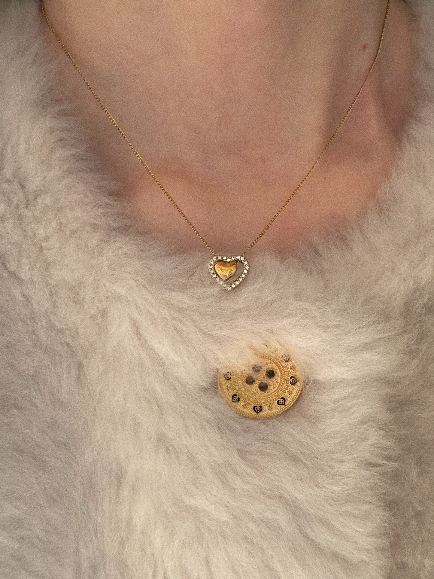 Model wearing the Fluttering Heart Necklace, showing the dancing gold pendant resting on the collarbone.