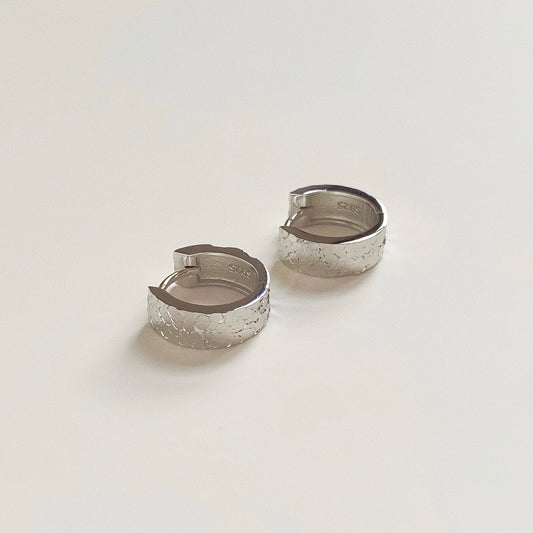 Solid Sterling Silver hoop earrings lying flat, showing S925 hallmark stamp and thick durable design.
