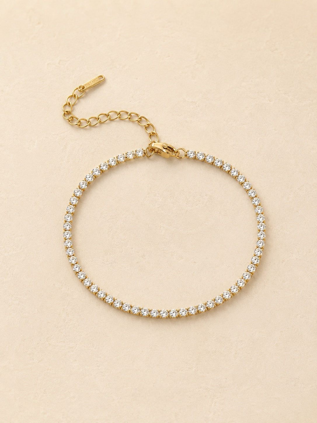 Gold tennis bracelet set with round cubic zirconia stones, adjustable extender and Deja Vu tag, waterproof stainless steel