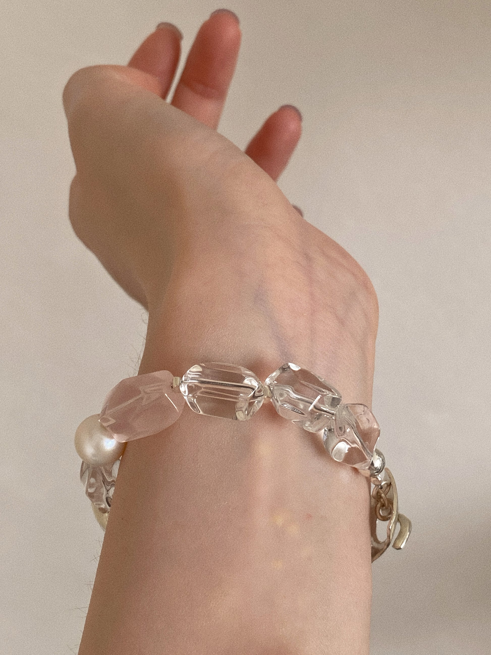 Chunky faceted clear quartz crystal bracelet worn on the wrist, showing the icy transparent nuggets and rose quartz in natural light