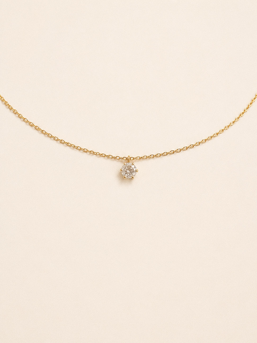 Icon cz solitaire necklace with a six claw round stone floating on a fine gold chain