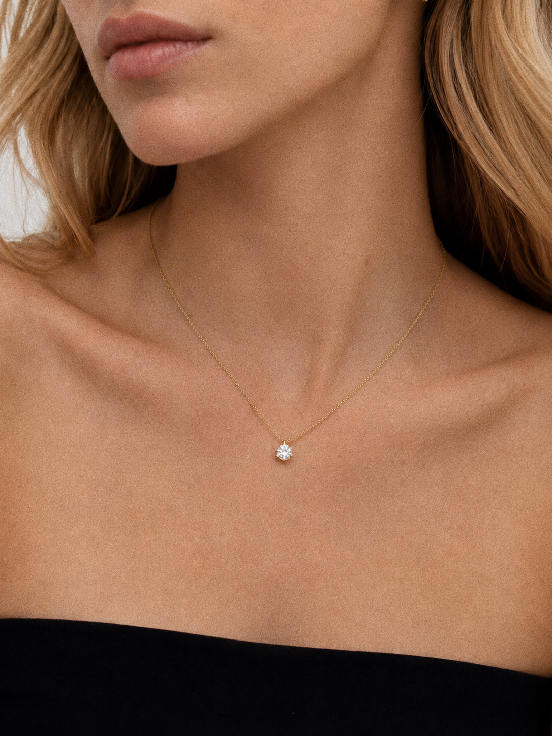 Model wearing the Icon cz solitaire necklace sitting at the collarbone on a fine gold chain