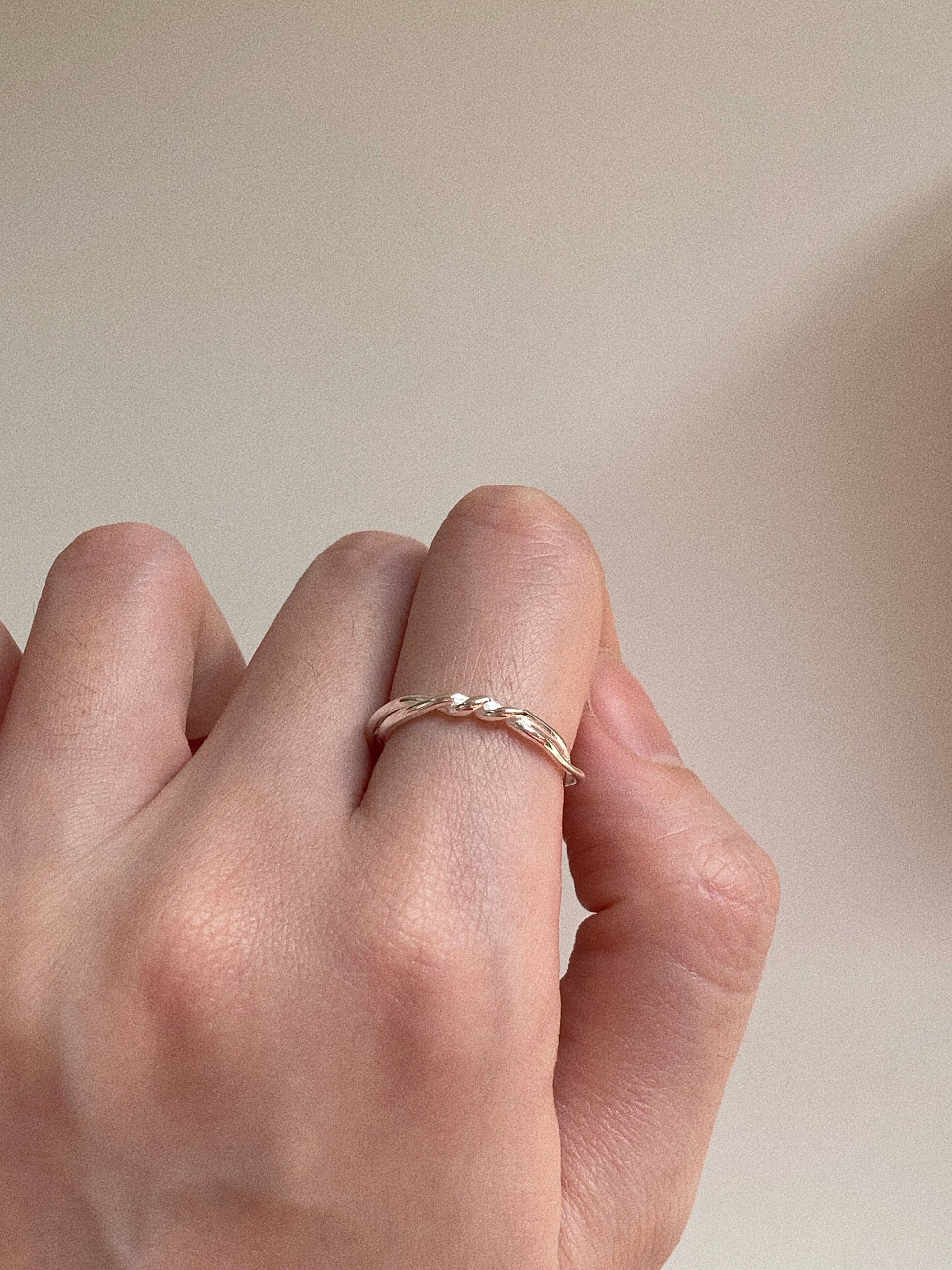 Close-up of the Twin Tide ring being worn on a finger, showcasing its dainty yet layered aesthetic.