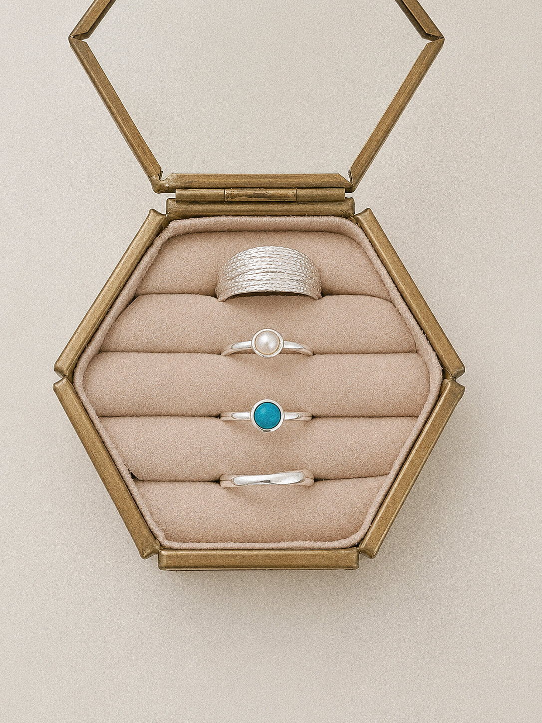 Cove dainty turquoise ring styled with pearl, textured and polished sterling silver rings in a jewellery display.