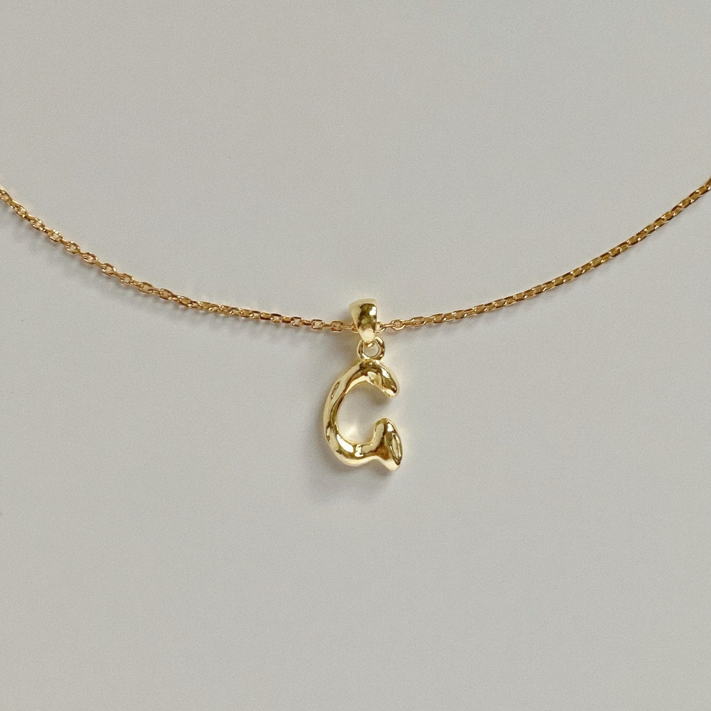 Detail shot of delicate gold chain links, perfect for layering necklaces.