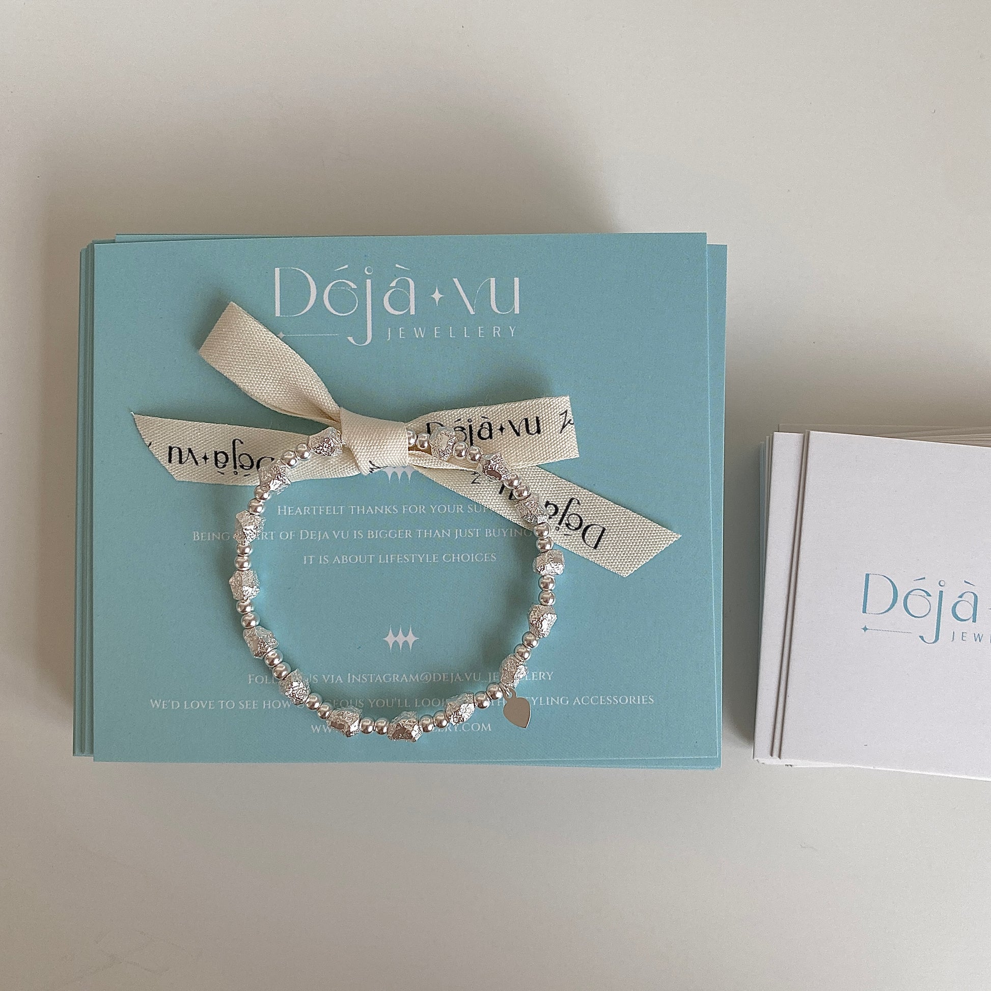 Solid silver elastic bracelet displayed on a teal Deja vu gift box, ready for gifting.