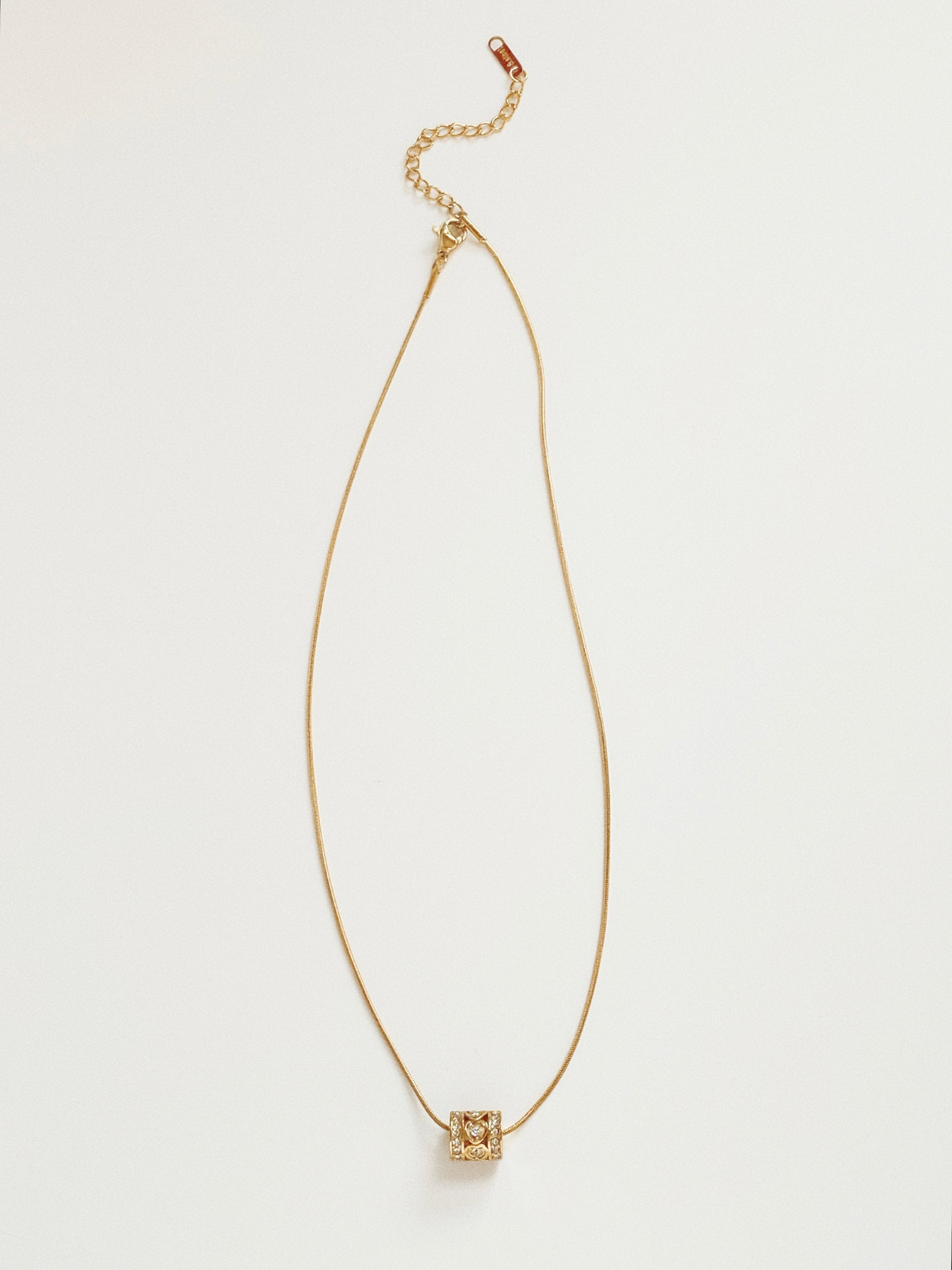 Full length view of waterproof gold snake chain necklace with a sliding heart kaleidoscope pendant.