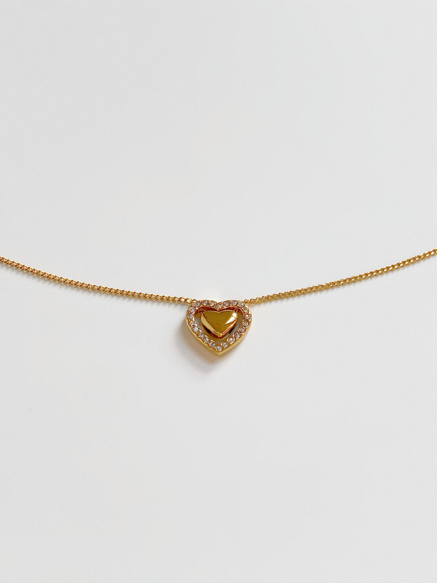 Full length view of the gold dancing heart necklace showing the dainty cable chain and lobster clasp.