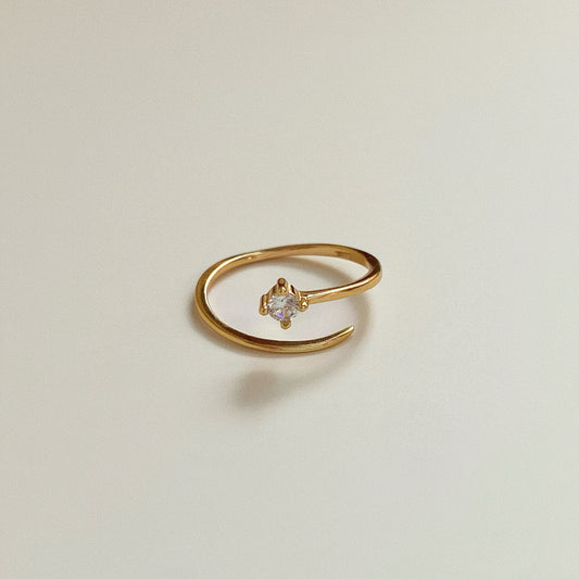 Dainty 18k gold plated sterling silver pinky ring with one cubic zirconia in claw setting on neutral background