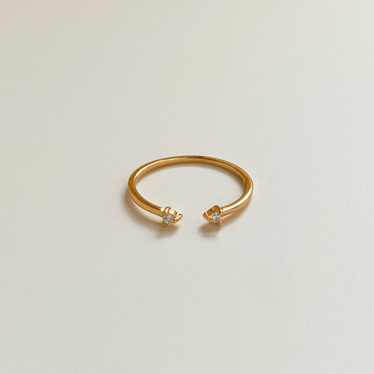 Gold open ring with twin cubic zirconia on neutral background