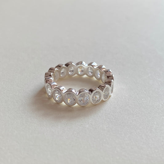 Single oval bezel eternity ring standing upright, full-eternity cubic zirconia set in polished 925 sterling silver.