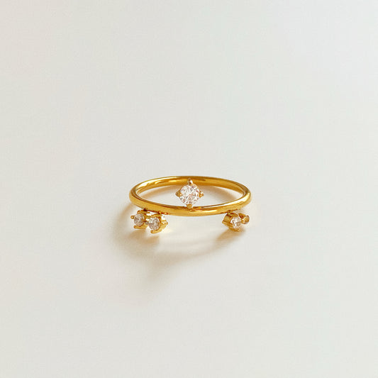 Close up of dainty gold ring with three scattered floating crystals, waterproof stainless steel jewellery.