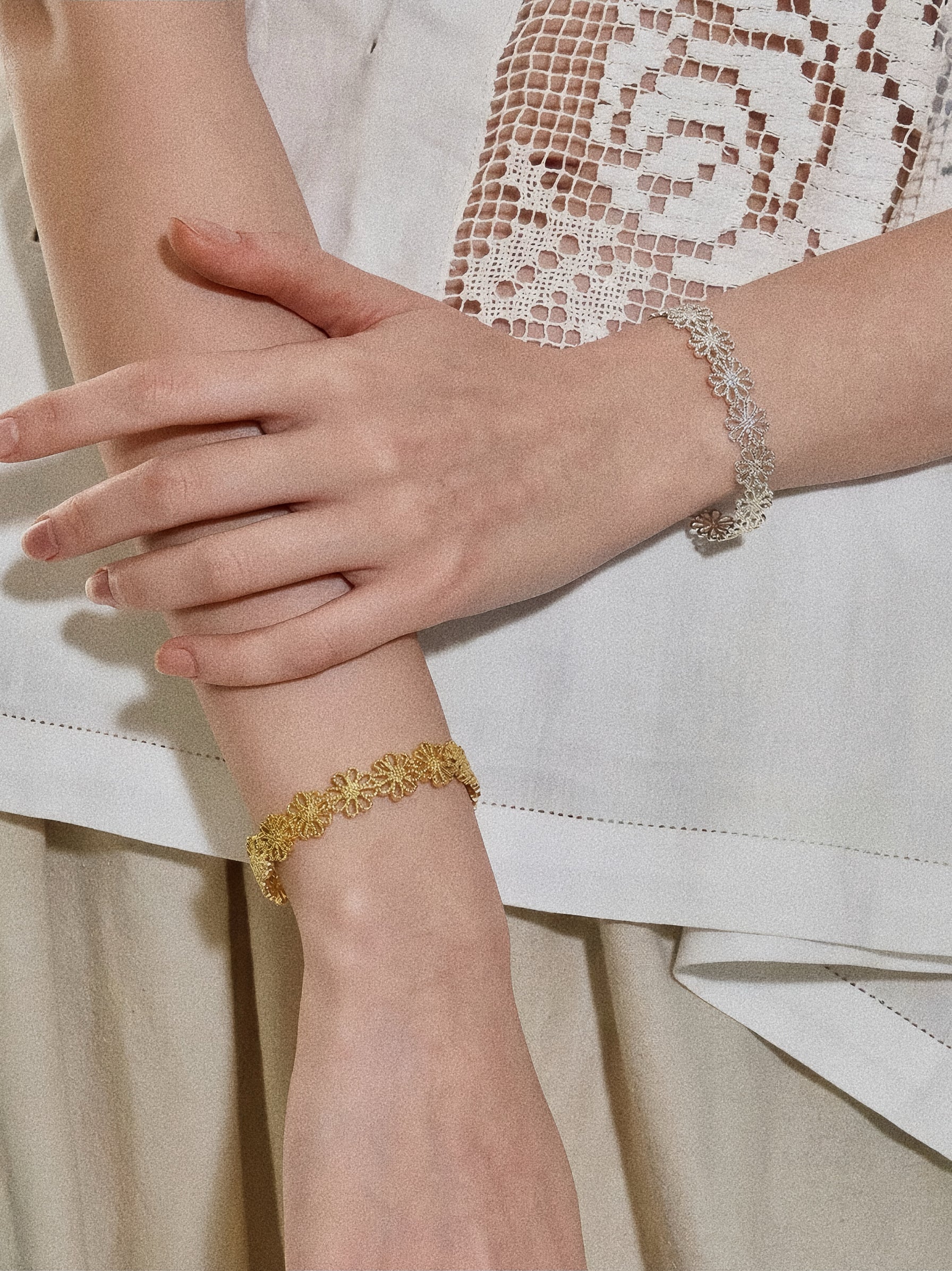 Gold and silver daisy lace cuff bracelets styled stacked on wrists for mixed-metal layering by Deja Vu Jewellery