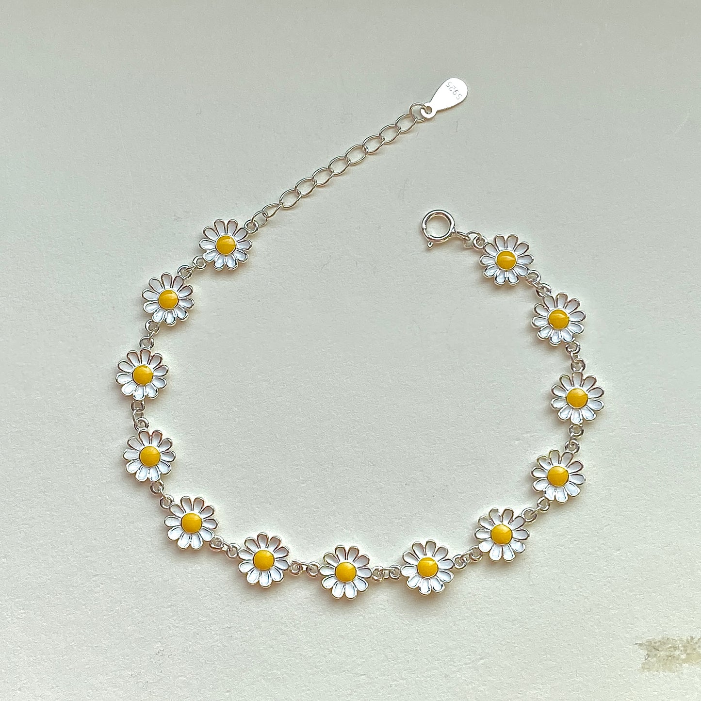 Sterling silver daisy enamel bracelet with extender, flat lay