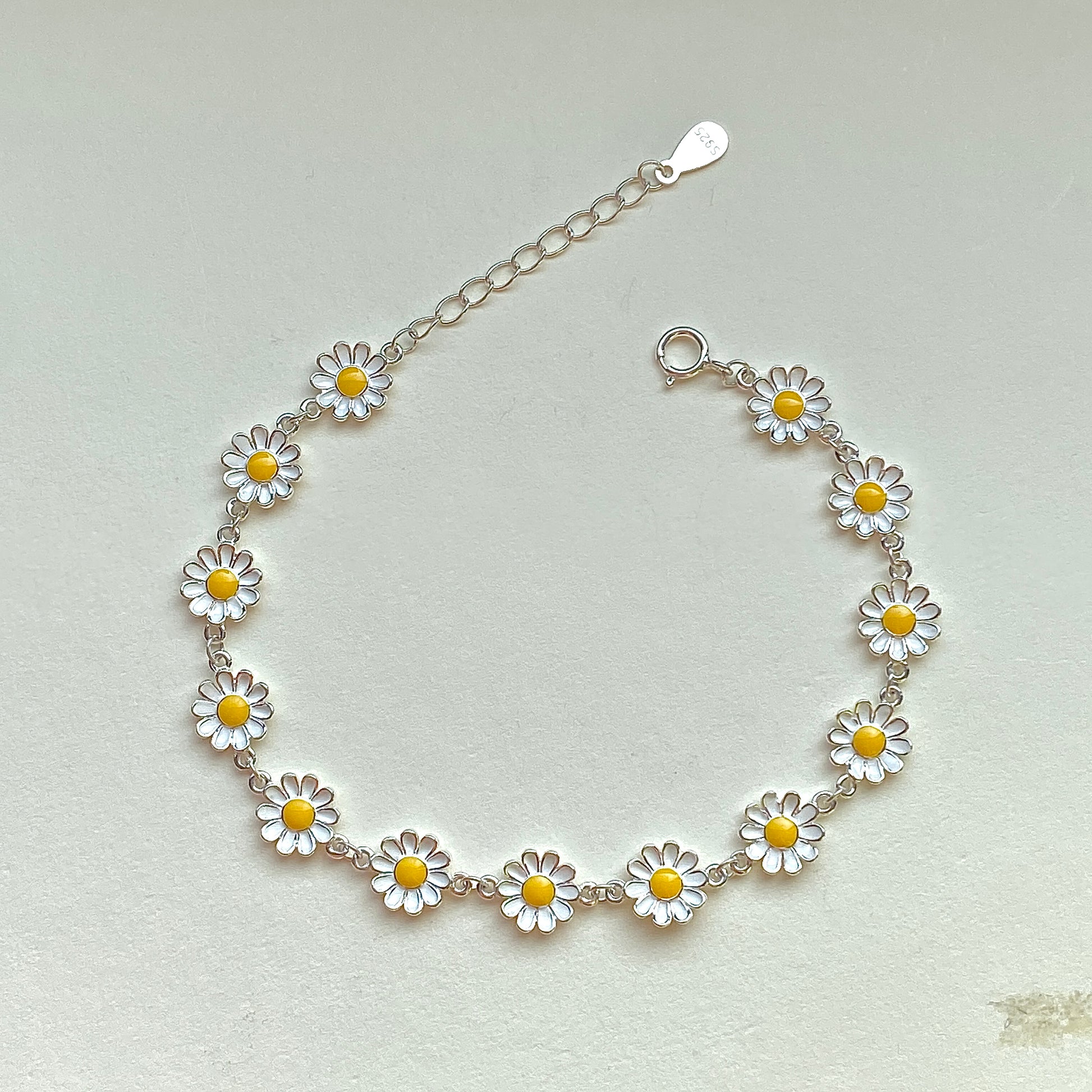 Sterling silver daisy enamel bracelet with extender, flat lay