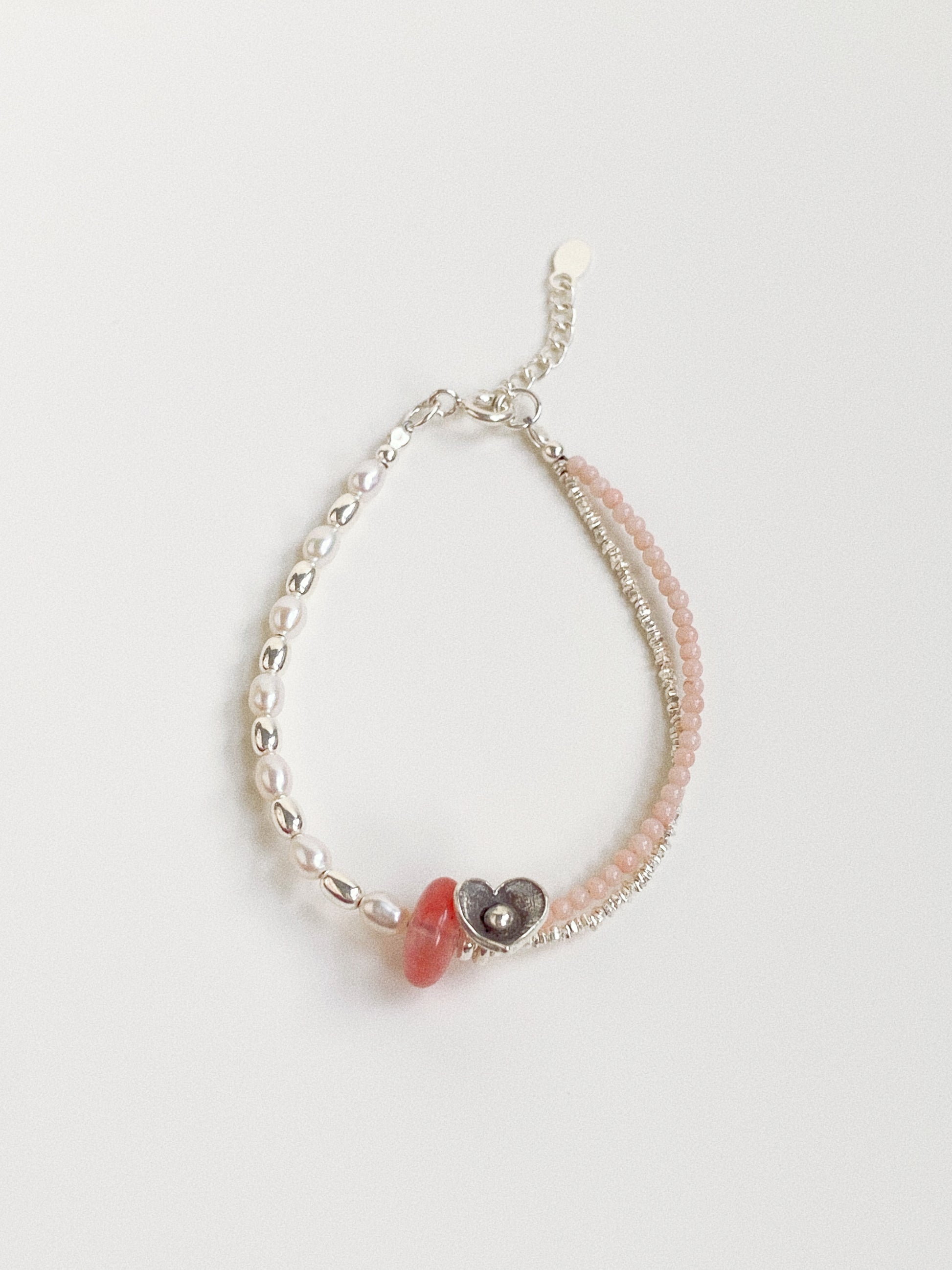 A handmade fashion bracelet featuring natural freshwater pearls, cherry quartz, and a pink coral disc from Deja vu Jewellery.