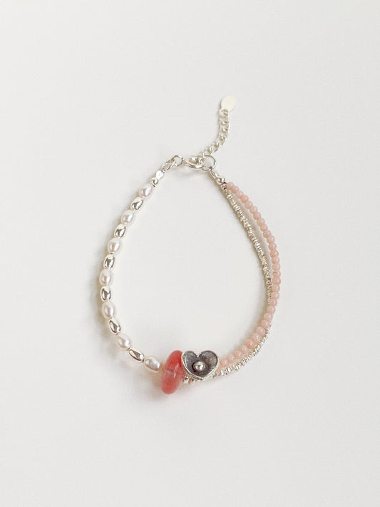 A handmade fashion bracelet featuring natural freshwater pearls, cherry quartz, and a pink coral disc from Deja vu Jewellery.