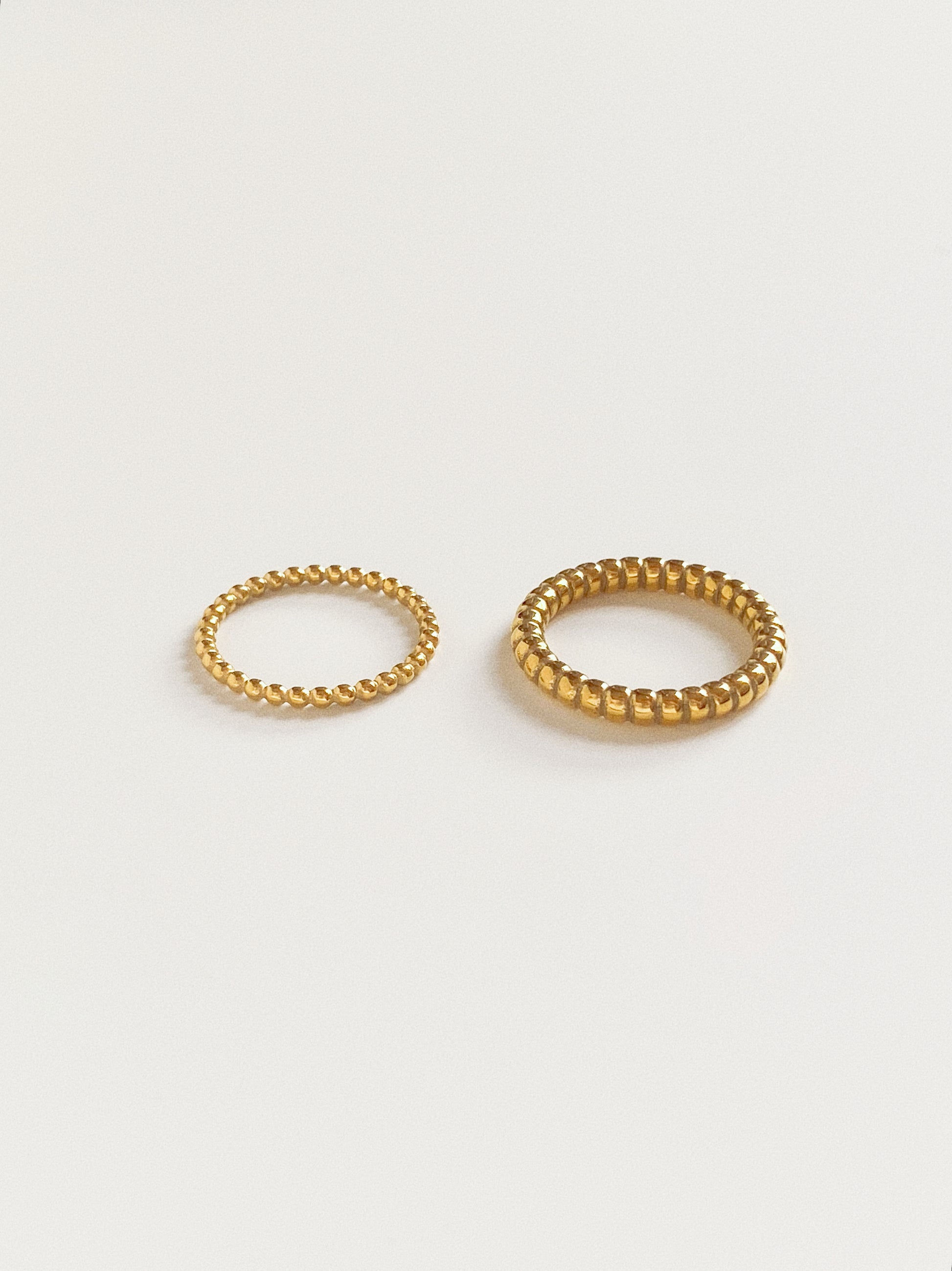 Wide and narrow gold beaded stacking rings in tarnish-free titanium steel by Deja vu Jewellery.